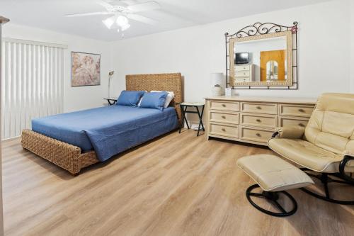 a bedroom with a bed and a dresser and a mirror at Sea Woods Home 4205 in New Smyrna Beach