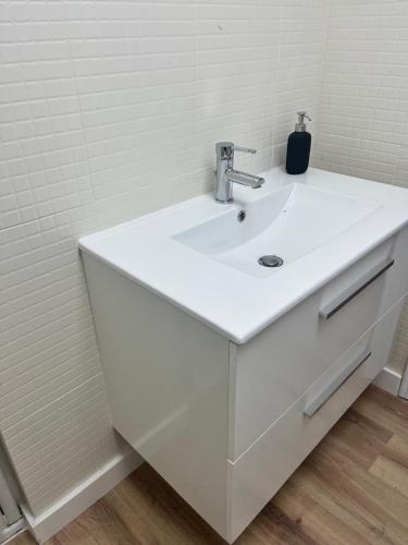 a white sink in a bathroom with white tiles at Casa Portalet in Xàtiva