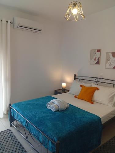 a bedroom with a bed with a blue blanket at Calm Rooms in Agioi Apostoli