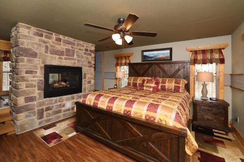 a bedroom with a stone wall with a bed and a fireplace at Firefly Nights – 5-Bed Mountain Chalet with Private Theater and Elevator in Gatlinburg