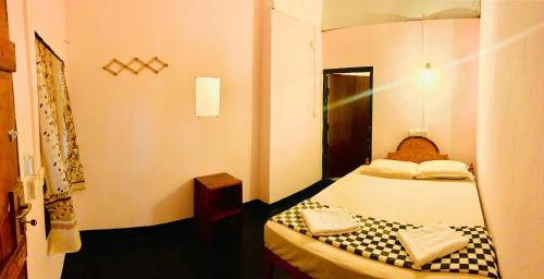 a small room with a bed and a mirror at Blue Vibe in Arugam Bay