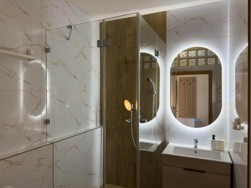 a bathroom with a shower and a sink and a mirror at The Minimalist Suite in Šurany