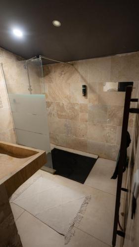 a bathroom with a shower with a stone wall at Maison avec spa in Maisdon-sur-Sèvre