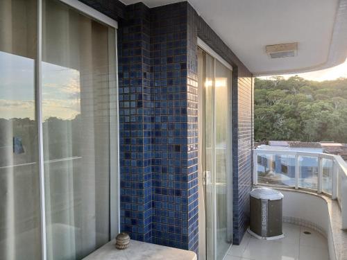 a balcony with a blue tile wall and a window at Privileg in Ilhéus