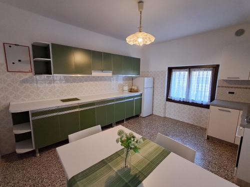 a kitchen with green cabinets and a table in it at Casa Nonna Adelaide in Roncone