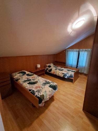 two beds in a room with wooden floors at Casa Nonna Adelaide in Roncone