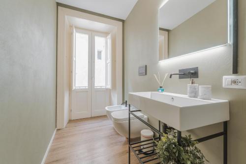 a bathroom with a white sink and a toilet at Palazzo Lucatelli Suite - Centro in Trapani