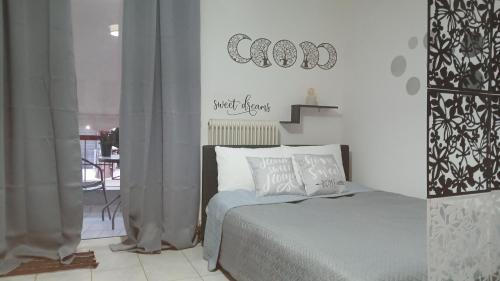 a bedroom with a bed and a sign on the wall at Welcome studio in Preveza