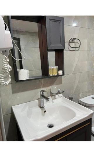 a bathroom with a sink and a mirror and a toilet at Wadi rum lacshre in Disah