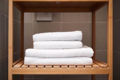 a stack of towels on a towel rack in a bathroom at TORTORELLA Apartments in Gorizia