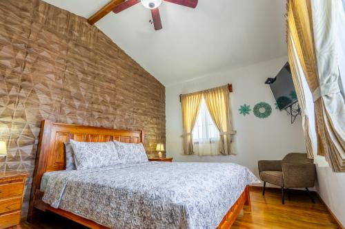 a bedroom with a bed and a brick wall at Faro del Colibri in Bocas Town
