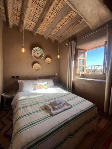 a bedroom with a large bed with a window at Heritage House Skoura in Skoura