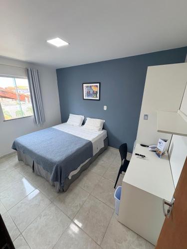 a bedroom with a bed with a blue wall at Belaris HOTEL EXECUTIVO - Próximo a Praia do Calhau in São Luís