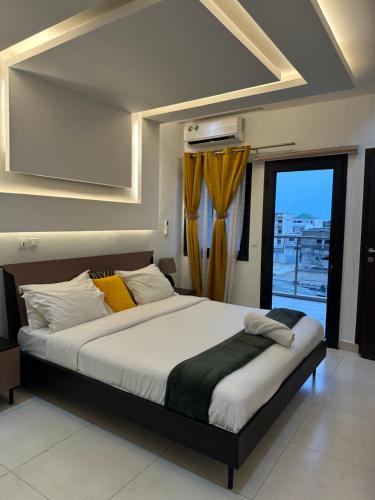 a bedroom with a large bed with a window at Voyage d'affaires et séjour paisible in Abidjan