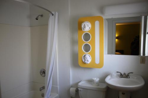 a bathroom with a toilet and a sink and a mirror at Bermuda Palms Hotel in San Rafael