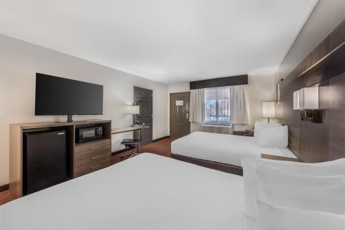 a hotel room with two beds and a flat screen tv at Best Western Dos Rios in Junction