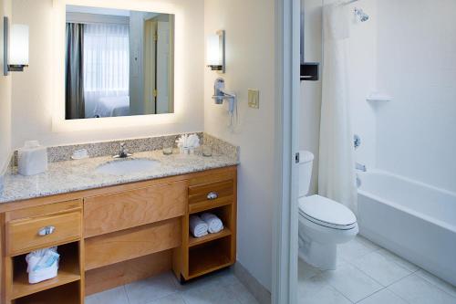 a bathroom with a sink and a toilet and a mirror at Homewood Suites by Hilton Albuquerque Uptown in Albuquerque