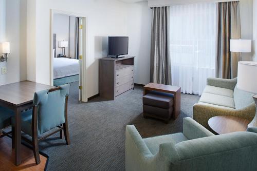 a hotel room with a bed and a living room at Homewood Suites by Hilton Albuquerque Uptown in Albuquerque