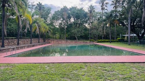 a swimming pool in a park with palm trees at The Urban Nest in Nelspruit