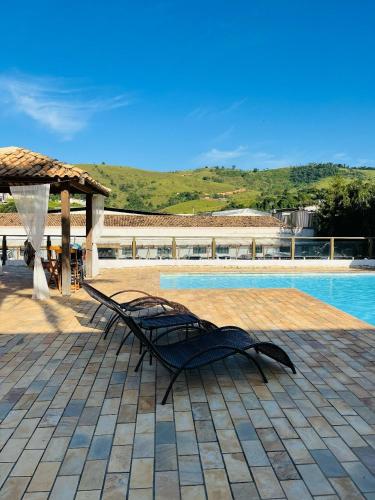 a black bench sitting next to a swimming pool at Prime Garden Pousada in Socorro