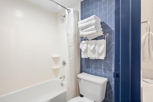 a bathroom with a toilet and a shower and towels at Spark by Hilton Bettendorf Quad Cities in Bettendorf