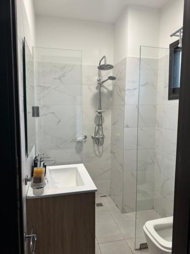 un bagno con lavandino e doccia in vetro di Tranquilité et confort comme à la maison a Abidjan
