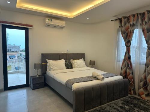 una camera da letto con un letto e una grande finestra di Tranquilité et confort comme à la maison a Abidjan