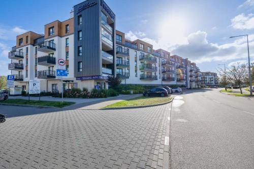 a street with buildings and cars parked on the road at BelMare Seaside Apartment by Solarento in Międzyzdroje