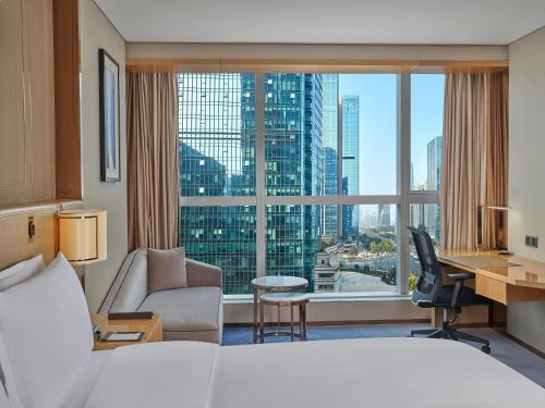 una camera d'albergo con un letto e una grande finestra di Hilton Chengdu a Chengdu