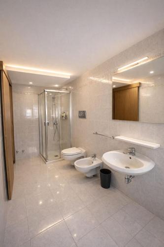 a bathroom with two sinks and a shower and a toilet at Vinessa Rooms in Sirmione