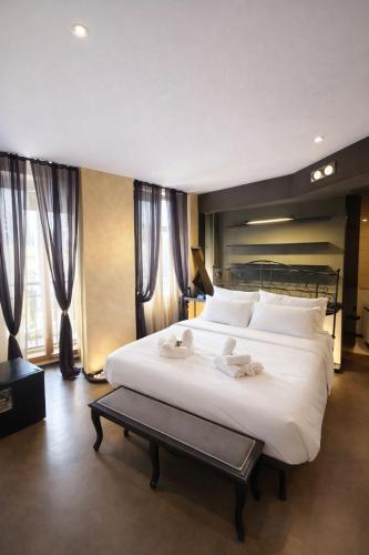 a bedroom with a large white bed with towels on it at Vinessa Rooms in Sirmione