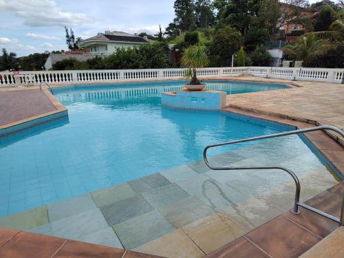 a large swimming pool with a white fence at Piemonte Flat Serra Negra in Serra Negra