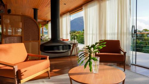 a living room with two chairs and a fireplace at Siramat Hotel in Petrópolis