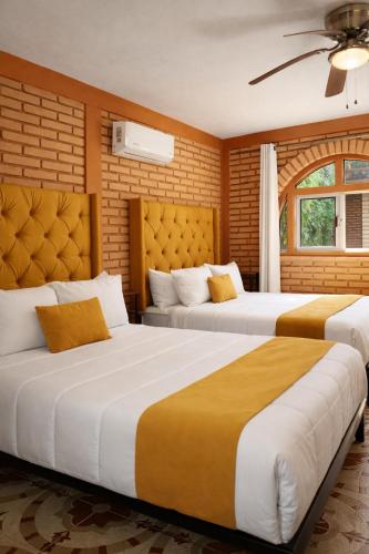 two beds in a hotel room with two beds at Hotel Flamora-Valle de Guadalupe in Francisco Zarco