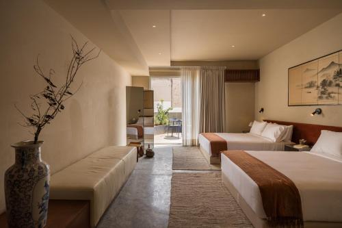 a hotel room with two beds and a couch at Hotel Oculto in Mexico City