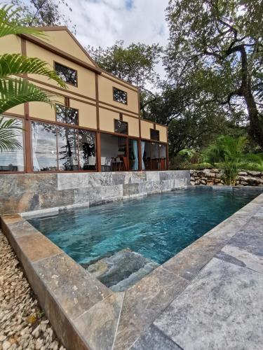 a swimming pool in front of a house at Villa Palladio Carrillo in Hojancha