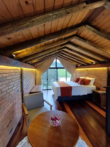 a bedroom with a bed and a table in a room at Cabana Morro das Pedras in Armazém