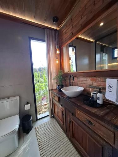 a bathroom with a sink and a toilet and a mirror at Cabana Morro das Pedras in Armazém