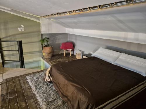 a bedroom with a large bed and a red chair at Manipa Loft 2 in Cafayate