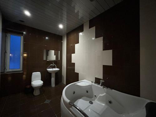 a bathroom with a tub and a toilet and a sink at Payl Hotel in Arrinj