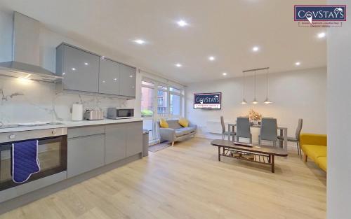 a kitchen and living room with a table and chairs at Beauchamp House - 2-bed apartment in Coventry City Centre, Free Parking, by COVSTAYS in Coventry