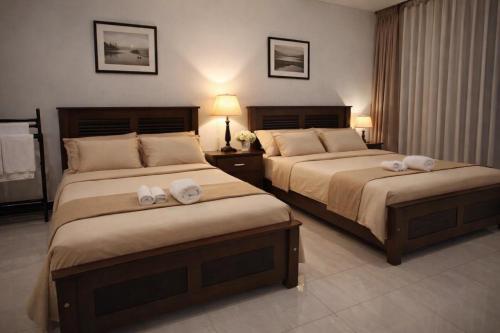 two beds in a hotel room with towels on them at Emerald Sea Breeze - Madiha in Nikawatawana
