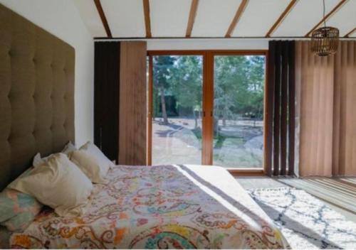 a bedroom with a large bed and a large window at El Campirri in Daimés