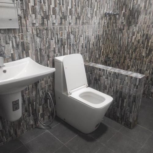 a bathroom with a white toilet and a sink at Emerald Sea Breeze - Madiha in Nikawatawana