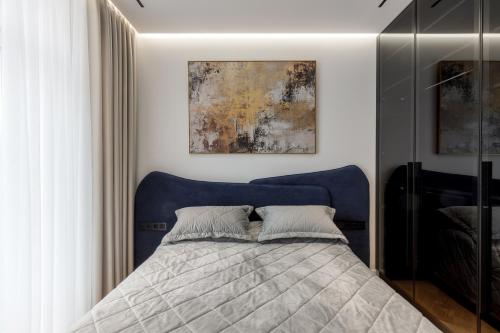 a bed with a blue headboard in a bedroom at Renest Milano Elegance Stay in Chişinău