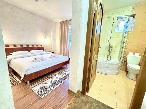 a bedroom with a bed and a shower and a toilet at Котедж в ГОРАХ in Solochyn