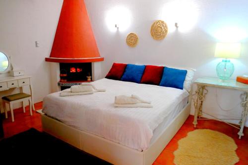 a bedroom with a bed with red and blue pillows at The Lodge apartment in Mesongi