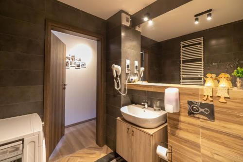 a bathroom with a sink and a mirror at Kurort Kozubnik Daglezja D23 Vista Stay in Porąbka