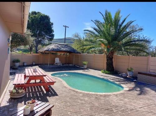 a backyard with a swimming pool and a picnic table at Little Waters Bnb in Queenstown