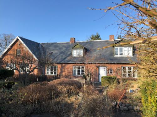 a red brick house with a black roof at Vejlø Skole - Degnegaarden in Næstved